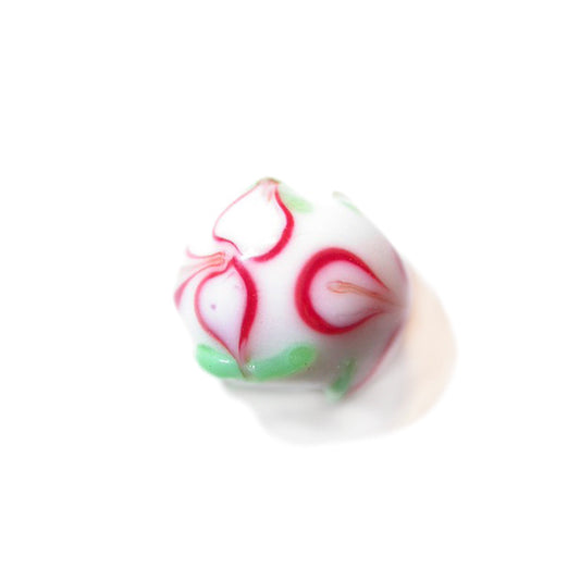 White, round glass bead painted with red and green