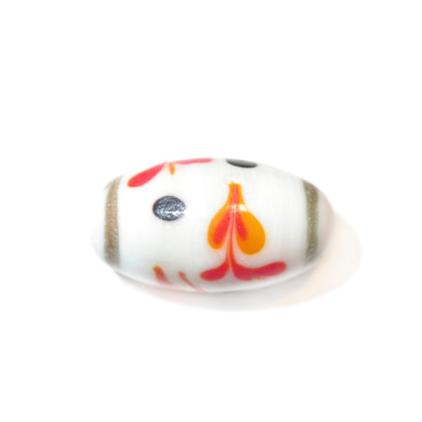 White, oblong glass bead with decoration