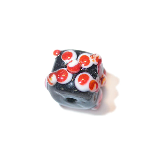 Black, square glassbead with red and white decoration