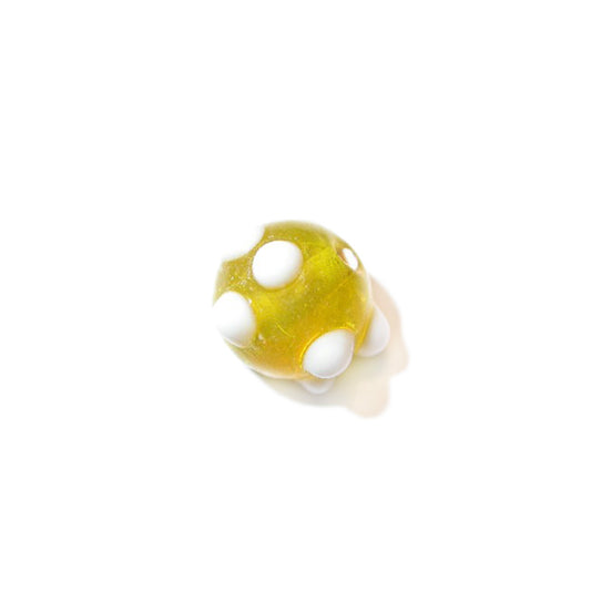 Yellow glass bead with white dots